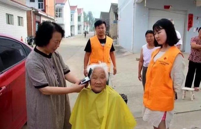 圖為栗紅連在進(jìn)行義務(wù)理發(fā)