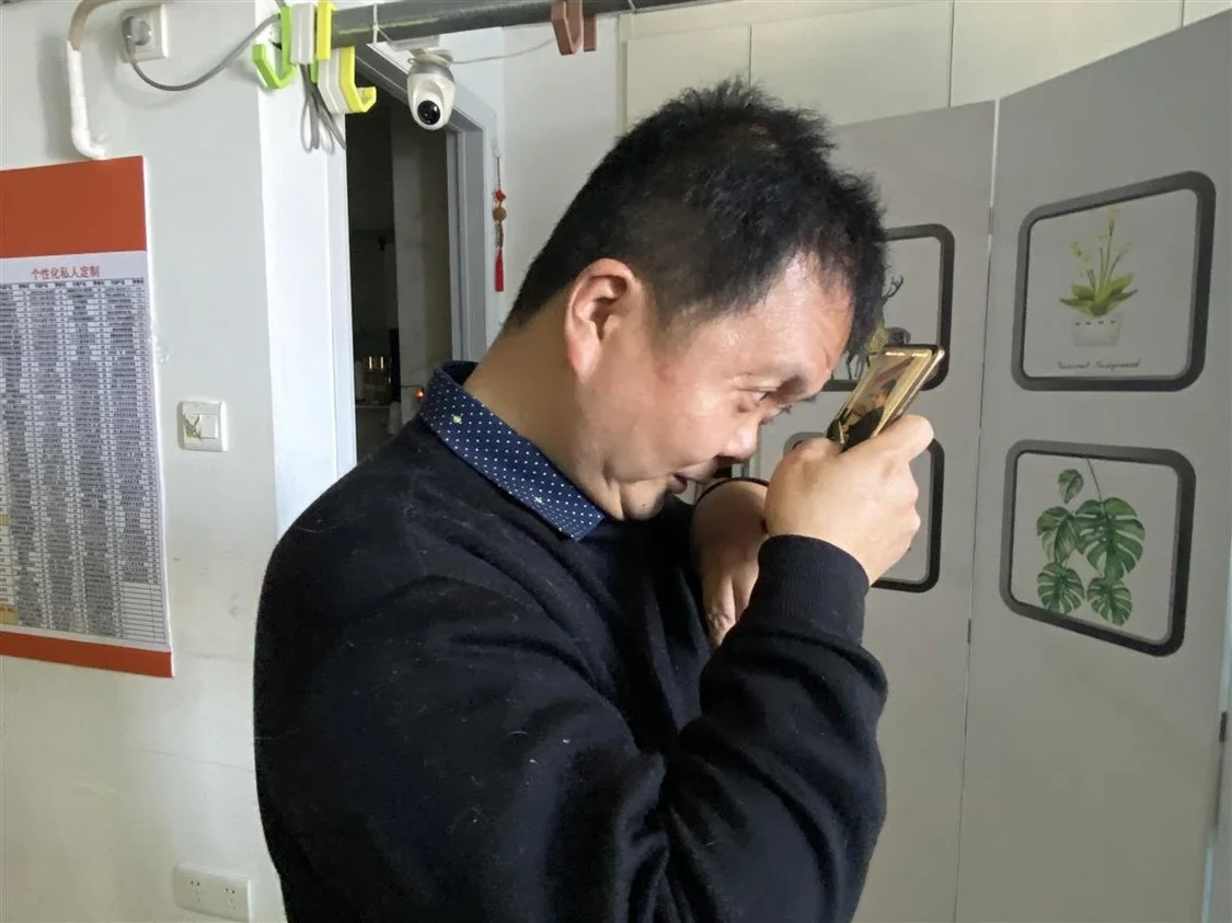 圖為孫林用手機與客戶溝通
