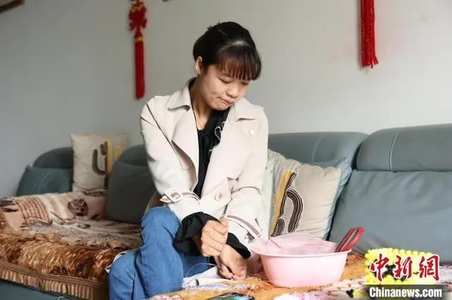 圖為李紅燕在制作串珠工藝品