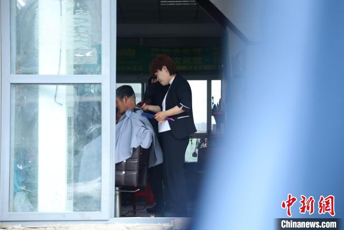 圖為周麗麗正在給客人理發(fā)