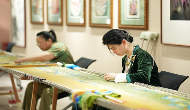 圖為受助殘疾女性展示漢秀千里江山圖