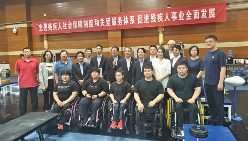 圖為代表團(tuán)與我國運(yùn)動員合影