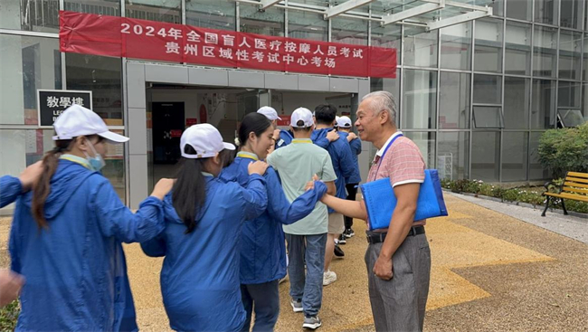 圖為廣西盲按中心負(fù)責(zé)人鼓勵進(jìn)入考場的廣西考生