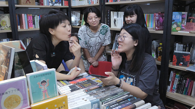 圖為康復(fù)老師指導(dǎo)聽力殘疾人發(fā)音