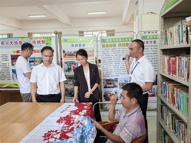 圖為與會(huì)人員參觀來(lái)賓市肢殘人協(xié)會(huì)
