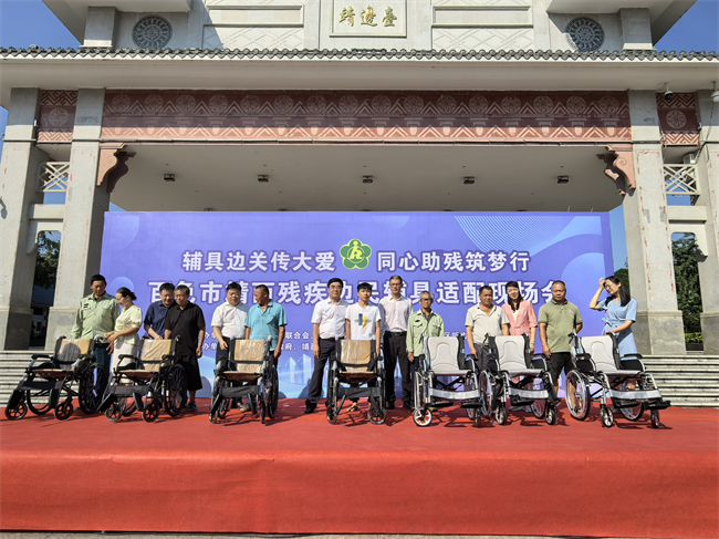 圖為出席活動(dòng)的領(lǐng)導(dǎo)為殘疾邊民免費(fèi)配發(fā)輔具